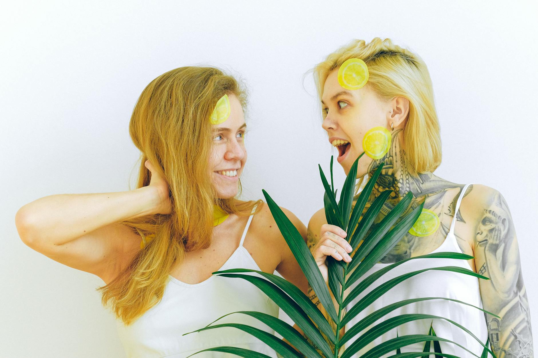 Two women smiling together expressing joy and confidence with yellow botanical elements