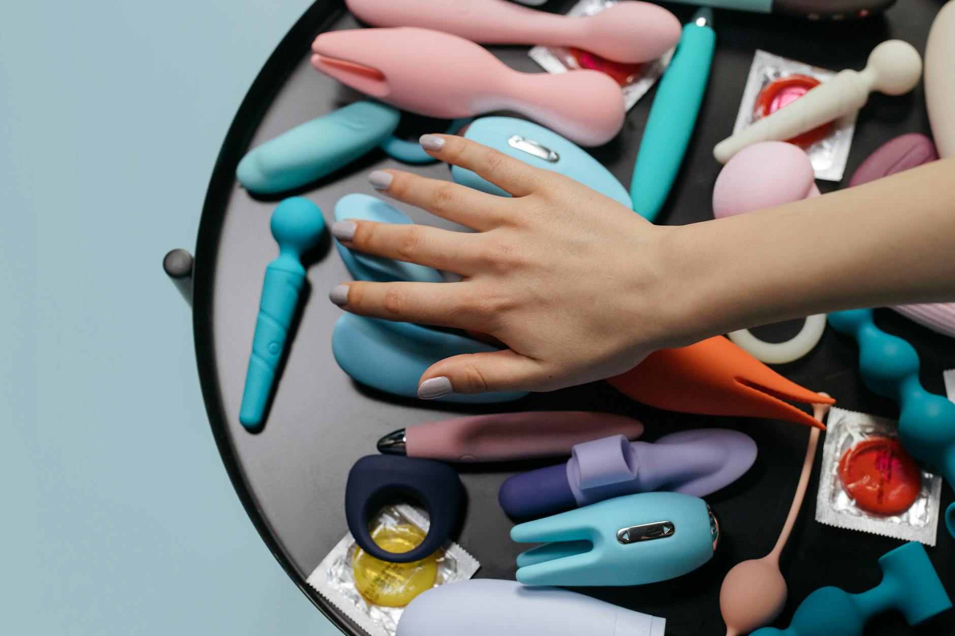 A collection of colorful sex toys arranged on a white surface, symbolizing variety and sensation exploration.