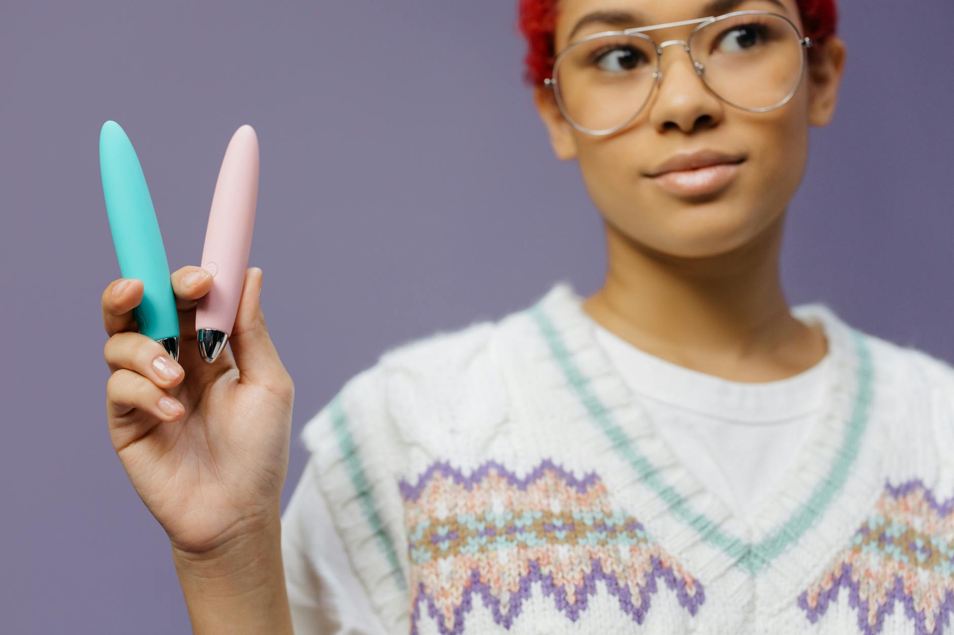 A blue silicone clitoral vibrator held in hand, promoting safe and intentional pleasure